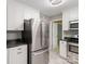 Modern kitchen featuring white cabinets, stainless appliances, and a door to another room at 2731 Creekbed Ln, Charlotte, NC 28210