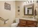 Half bath with granite countertop vanity, decorative wall art, and accessibility bar at 3022 8Th Street Ne Ct, Hickory, NC 28601