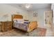 Well-lit bedroom with a bamboo-style bed, a vintage dresser, and an open bathroom offering a comfortable living space at 3022 8Th Street Ne Ct, Hickory, NC 28601
