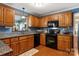 Traditional kitchen boasts wooden cabinets, granite countertops, and modern black appliances at 3022 8Th Street Ne Ct, Hickory, NC 28601