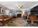 Spacious living room with a brick fireplace, ceiling fan, and colorful rug, ideal for Gathering gatherings at 3022 8Th Street Ne Ct, Hickory, NC 28601