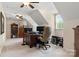 Well-lit office space featuring a spacious desk and a cozy chair under a sloped ceiling with a large monitor at 3022 8Th Street Ne Ct, Hickory, NC 28601