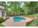 Inviting kidney-shaped pool surrounded by lush landscaping and a patio, perfect for outdoor relaxation and entertainment at 3022 8Th Street Ne Ct, Hickory, NC 28601