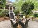 Landscaped backyard with patio, outdoor fireplace, stone walls, and lush greenery, great for relaxing at 3203 Blackburn Dr, Waxhaw, NC 28173