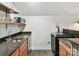 Wet bar area with granite countertop, stainless steel sink, shelving, and tile flooring in basement at 3203 Blackburn Dr, Waxhaw, NC 28173