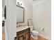 Powder bathroom features a decorative mirror, granite vanity, and toilet at 3203 Blackburn Dr, Waxhaw, NC 28173