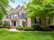 Traditional brick home featuring a manicured lawn, mature landscaping, and a welcoming front porch at 3203 Blackburn Dr, Waxhaw, NC 28173
