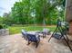 A large backyard features patio with seating and a lush green lawn and mature trees at 3313 Lancaster Hwy, Monroe, NC 28112