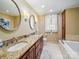 Elegant bathroom featuring double vanity with granite countertop and a soaking tub next to the walk-in shower at 3313 Lancaster Hwy, Monroe, NC 28112