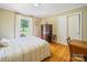 Cozy bedroom with hardwood floors, a window overlooking the yard, and an antique dresser at 3313 Lancaster Hwy, Monroe, NC 28112