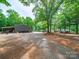 Wide gravel driveway and metal outbuilding on this large wooded lot at 3313 Lancaster Hwy, Monroe, NC 28112