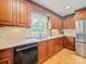 This kitchen features wooden cabinets, granite countertops, stainless steel refrigerator, and hardwood floors at 3313 Lancaster Hwy, Monroe, NC 28112