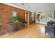 Bright sunroom boasts brick wall, light hardwood floors, a tall plant, and multiple windows for natural light at 3313 Lancaster Hwy, Monroe, NC 28112
