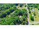 An aerial view of a tree-filled lot and a home surrounded by other neighborhood properties at 3317 Treyburn Dr, Midland, NC 28107