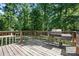 The spacious wooden back deck features a grill and overlooks a lush backyard with lots of trees at 3317 Treyburn Dr, Midland, NC 28107