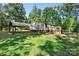 Spacious backyard with a detached carport and a wooden back deck with steps leading up to the home at 3317 Treyburn Dr, Midland, NC 28107