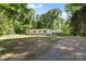 Spacious property showcasing a white single-story home with a carport and a generous front yard at 3317 Treyburn Dr, Midland, NC 28107