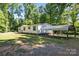 Single-story home with a carport surrounded by a lush, green lawn, offering a peaceful setting at 3317 Treyburn Dr, Midland, NC 28107