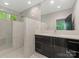 Modern bathroom featuring marble tile, a glass shower, a large mirror, and a black vanity with stone countertop at 3385 Rainbow Dr # 7A, Marvin, NC 28173
