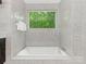 Bright bathroom featuring a soaking tub, marble tiling, and large windows offering outdoor views at 3385 Rainbow Dr # 7A, Marvin, NC 28173