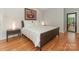 Bedroom showcasing a bed with crisp white linens, hardwood floors, and stylish bedside lighting at 3385 Rainbow Dr # 7A, Marvin, NC 28173