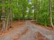 Long gravel driveway leading to a secluded home surrounded by lush trees and natural landscape at 3385 Rainbow Dr # 7A, Marvin, NC 28173