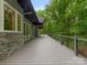 An expansive exterior deck features modern railing and offers a serene view of the surrounding lush greenery at 3385 Rainbow Dr # 7A, Marvin, NC 28173