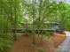 Exterior elevation nestled among mature trees featuring an expansive deck and professionally landscaped yard at 3385 Rainbow Dr # 7A, Marvin, NC 28173
