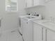 Laundry room featuring white washer and dryer, white cabinets, stone countertop, tile floors, and a window at 3385 Rainbow Dr # 7A, Marvin, NC 28173