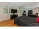 Bedroom with hardwood floors, a large mirror, a black bed, a TV and a closet at 3385 Rainbow Dr # 7A, Marvin, NC 28173