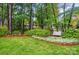Lush backyard showcasing mature trees, manicured lawn, and a wooden swing at 3804 Bellingham Ln, Charlotte, NC 28215