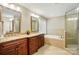 Bathroom with double sinks, granite countertops, soaking tub and a glass enclosed shower at 3804 Bellingham Ln, Charlotte, NC 28215