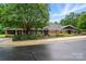 A well-maintained brick building with a classic design, complemented by mature trees and landscaping on a wet street at 3804 Bellingham Ln, Charlotte, NC 28215
