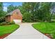 Charming brick home featuring a spacious driveway and attached garage surrounded by a lush, green lawn and mature trees at 3804 Bellingham Ln, Charlotte, NC 28215