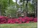 Brick home framed by trees and vibrant pink azaleas at 3804 Bellingham Ln, Charlotte, NC 28215