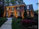 Well-lit brick home with a manicured lawn and walkway at 3804 Bellingham Ln, Charlotte, NC 28215
