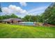 Community pool featuring a fenced area with a nearby playground and lush green grass on a sunny day at 3804 Bellingham Ln, Charlotte, NC 28215