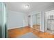 Clean bedroom with light blue walls, hardwood floors, and mirrored closet doors at 401 Clover Ln, Newton, NC 28658