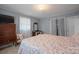 Serene bedroom with a floral patterned bedspread, dresser, and soft lighting for a peaceful retreat at 401 Clover Ln, Newton, NC 28658