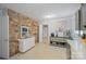 Country kitchen features a stone accent wall, neutral cabinets, and view to another room at 401 Clover Ln, Newton, NC 28658