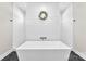Modern soaking tub with a full tile surround in a bright bathroom with black accent floor tiles at 4453 Buffalo Shoals Rd, Maiden, NC 28650