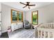 Bright Bedroom featuring a crib, comfortable chair, and windows with green views at 4453 Buffalo Shoals Rd, Maiden, NC 28650