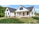 Detailed view of a two-story home's front porch, featuring rocking chairs, white siding, and craftsman-style details at 4453 Buffalo Shoals Rd, Maiden, NC 28650