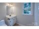 Clean bathroom features a classic vanity with ample lighting and a window view at 4501 Bainview Dr, Mint Hill, NC 28227