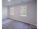 Bright bedroom with neutral carpet, featuring two windows offering natural light and outdoor views at 4501 Bainview Dr, Mint Hill, NC 28227
