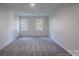 Bright bedroom with soft carpet, neutral walls, and natural light from two windows at 4501 Bainview Dr, Mint Hill, NC 28227