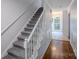 Carpeted staircase with white railing, leading to the upper level, with hardwood flooring visible at 4501 Bainview Dr, Mint Hill, NC 28227
