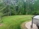 Spacious backyard with lush green lawn, mature trees, and an inviting patio area for outdoor enjoyment at 4561 N Wynswept N Dr, Maiden, NC 28650
