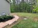 Lush green backyard with a stone walkway, surrounded by mature trees providing privacy and a serene setting at 4561 N Wynswept N Dr, Maiden, NC 28650