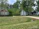 Expansive front yard with lush green grass, mature trees, and a long driveway leading to the houses at 4561 N Wynswept N Dr, Maiden, NC 28650